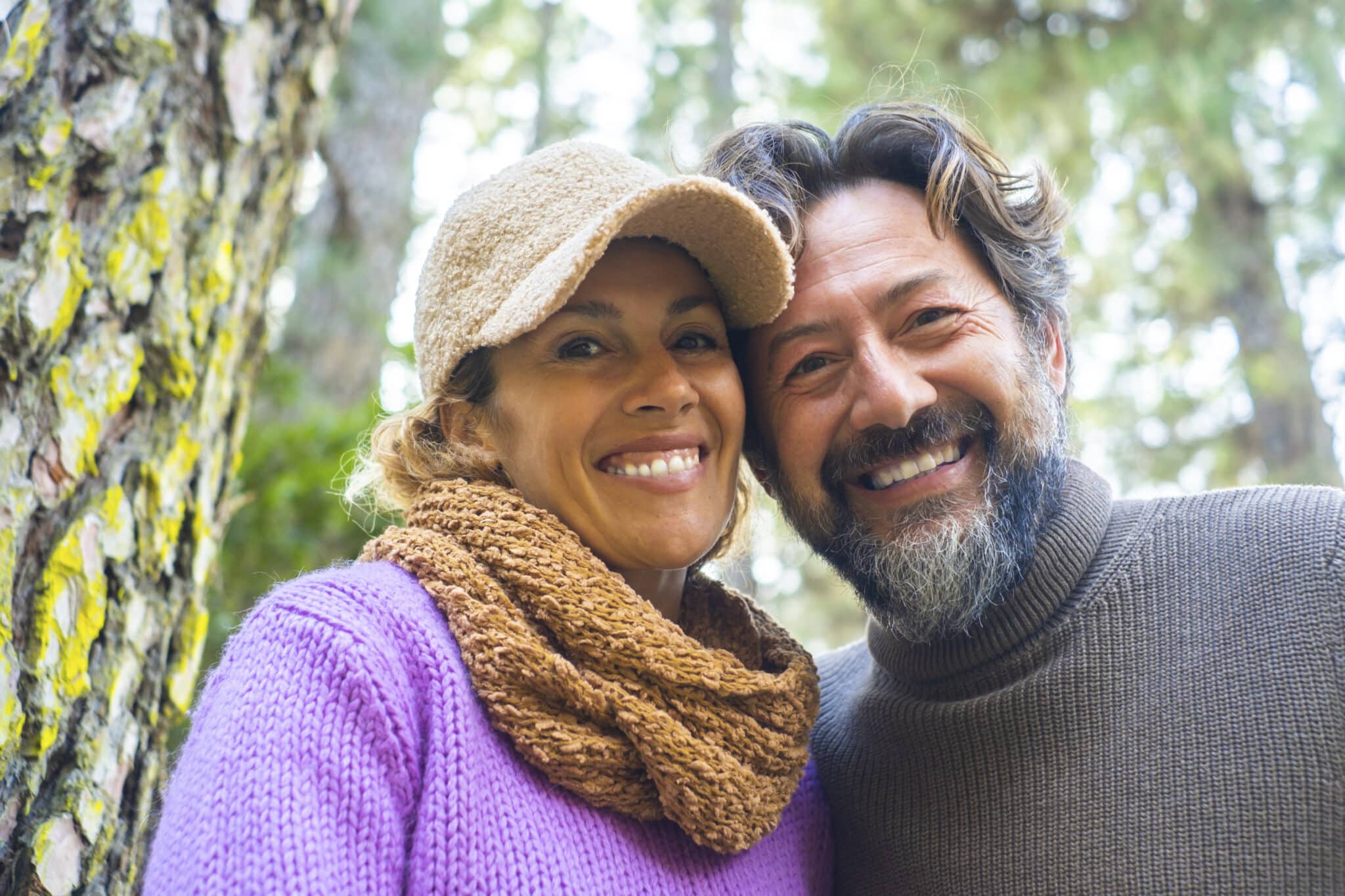 Cheerful and happy adult couple smile together at the camper in